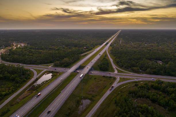 istock Highway intersection in Florida rural area at sunset. Elevated interchange lanes for express passing of car traffic 2193914753