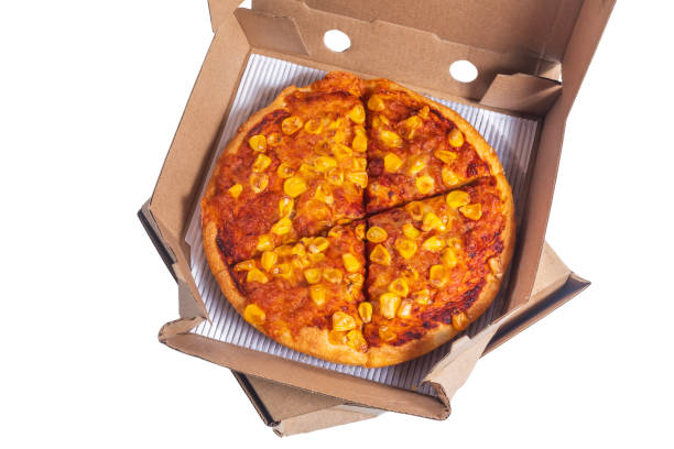 istock Delicious corn topped pizza in a cardboard delivery box on a white background, Top view 2193918546