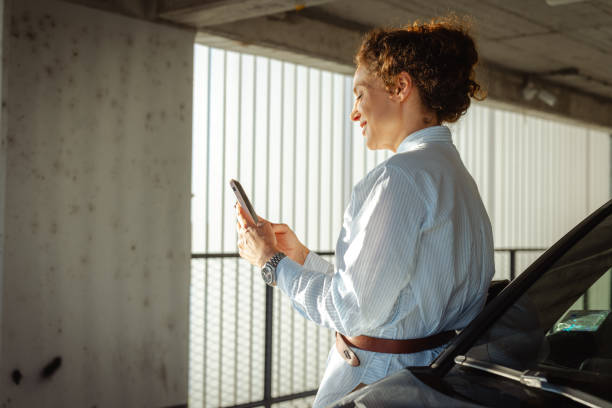 istock Young woman using smartphone outdoors in a sunny urban parking space 2193938734