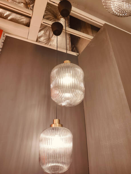 istock Two glass pendants hang from the ceiling in an interior design store 2193938946