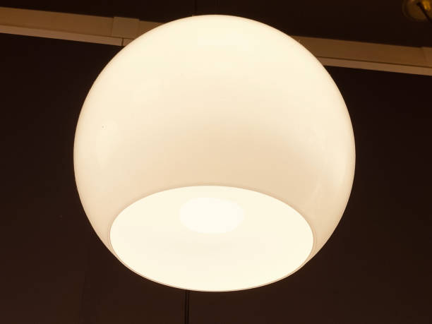 istock A white plastic ceiling light with an opening on the bottom, hanging from black walls 2193939009