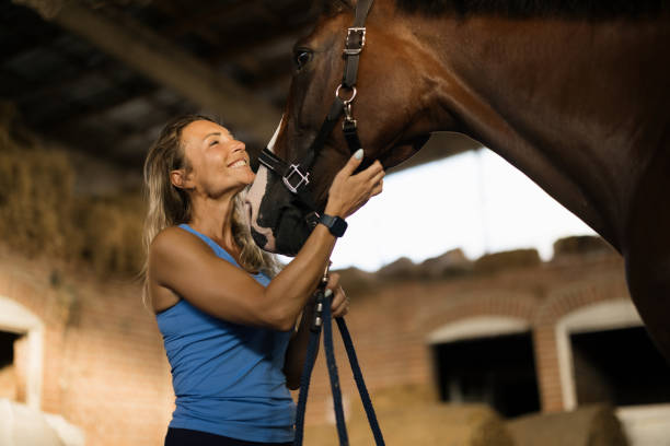 Happy Woman Bonding With Her Horse in Rustic Barn Setting