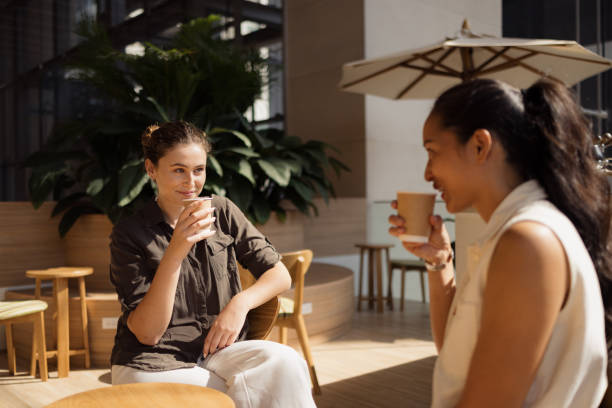 istock Two Women Enjoying Coffee Together in a Modern Indoor Cafe Setting 2193940861