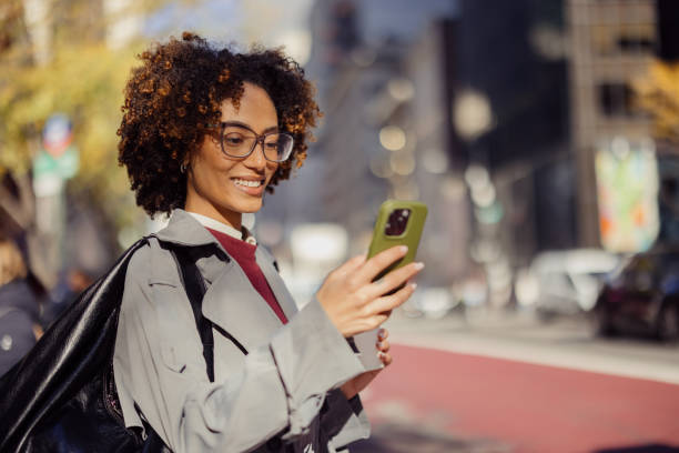 istock Smiling Woman Using Smartphone in an Urban Outdoor Setting 2193940978
