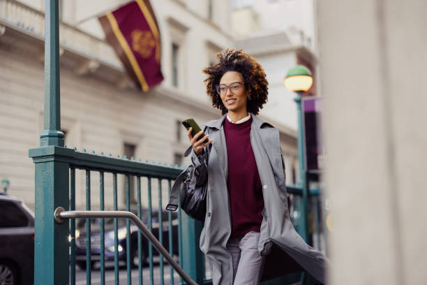 istock Confident Woman Walking Outdoors and Using Smartphone in Urban Setting 2193940982
