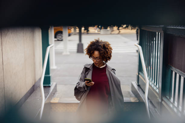 istock Young Woman Exiting Subway Station While Using Smartphone in Urban Setting 2193940986