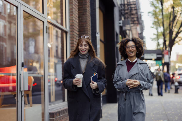 istock Two Women Strolling Together While Laughing on a City Street 2193940987