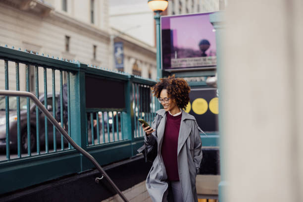 istock Confident Woman Smiling While Texting on Phone Outdoors Near Subway Entrance 2193940990