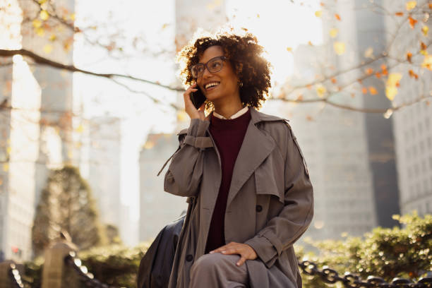 istock Smiling Woman Talking on Phone Outdoors In a Sunny Urban Environment 2193940991