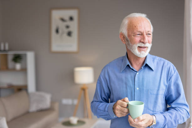 istock Senior man with a warm smile in a cozy living room setting 2193941121