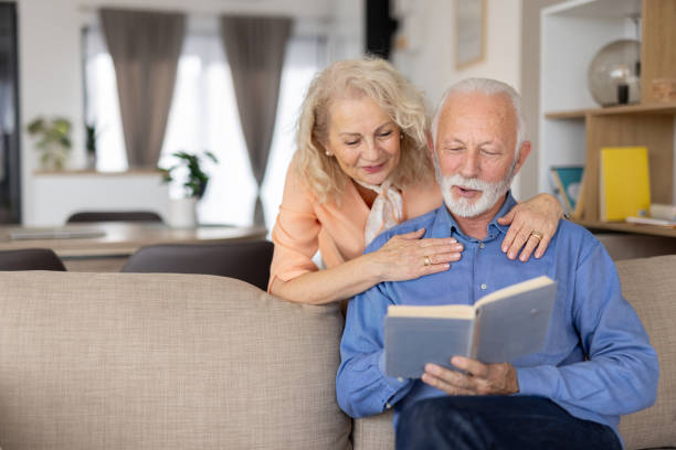 istock Happy couple enjoying book reading on a sofa 2193941134
