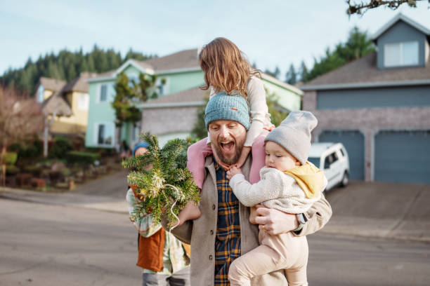 istock Happy multi-generation family carrying Christmas tree into their house 2193942251