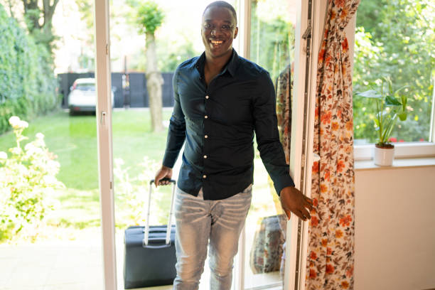 istock Man entering house with suitcase 2193944069
