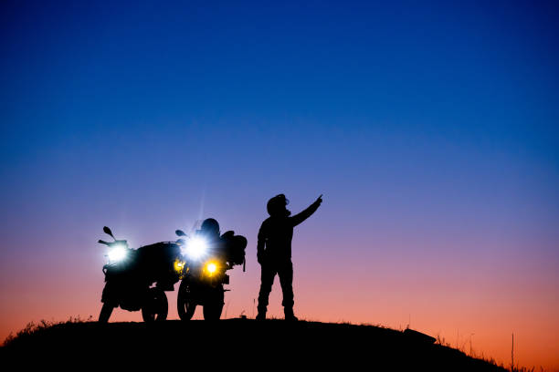 Silhouette of a man riding his motorcycle during sunset
