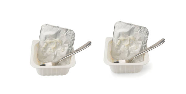 istock Empty yogurt cup isolated, yoghurt with orange fruits pieces in plastic pot, milk pudding container 2193949575