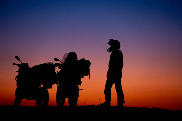 Silhouette of a man riding his motorcycle during sunset