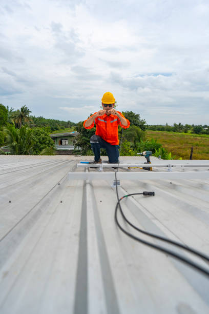 istock Technician in safety uniform and helmet kneeling on a rooftop, using a drill for precise installation work. A scene highlighting safety, professionalism, and technical expertise in construction. 2193952543