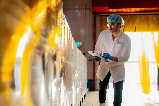 istock Technician inspecting stacked products in a brightly lit warehouse Focus on quality control logistics and industrial efficiency in modern manufacturing settings. 2193956834