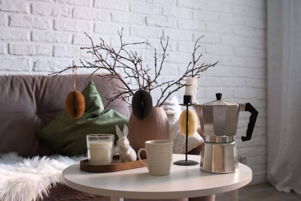 istock A beautifully cozy living room with modern easter home decor that includes vase with dry branches and eggs, coffee pot, ceramic rabbit,candle, on coffee table. 2193956855