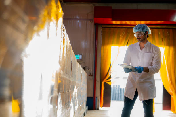 istock Technician inspecting stacked products in a brightly lit warehouse Focus on quality control logistics and industrial efficiency in modern manufacturing settings. 2193956924