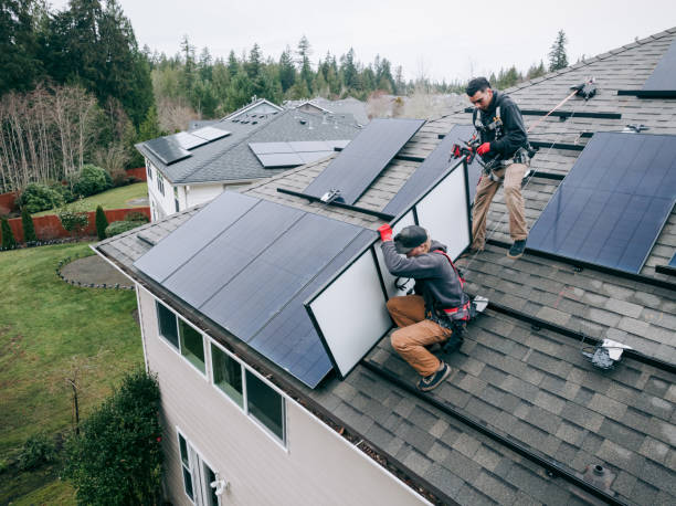 Aerial View of Solar Energy Technicians Working To Install Solar Panels on Residential Roof stock photo