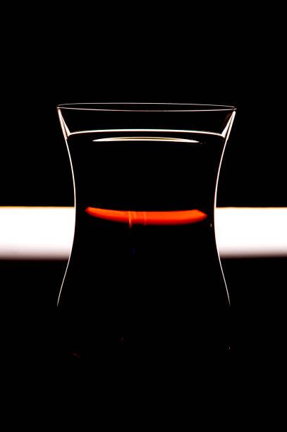 bottle of flavored vodka with a glass on a wooden background