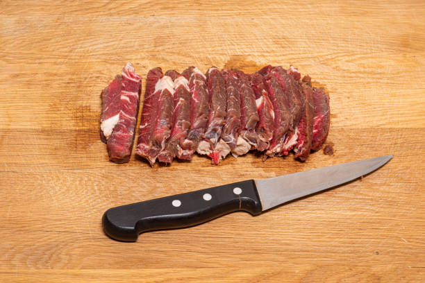 Close up of unrecognziable man cutting meat for the barbecue - Lifestyles