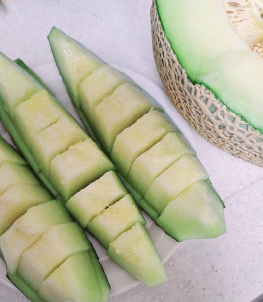 Fresh melon cubes neatly arranged in a bowl, showcasing their vibrant orange and green hues. A refreshing and visually appealing treat, perfect for any occasion.