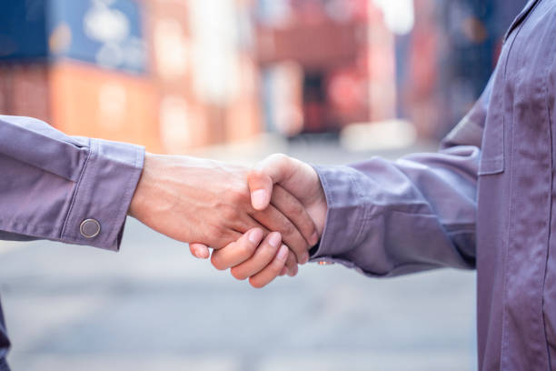 Close up of cargo container dock ship workers doing hands shake together on success