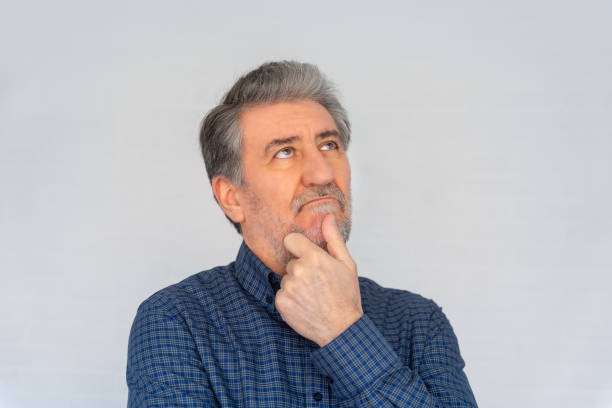 istock Senior man thinking with a gesture of doubts and looking up, photo with copyspace. 2193975220