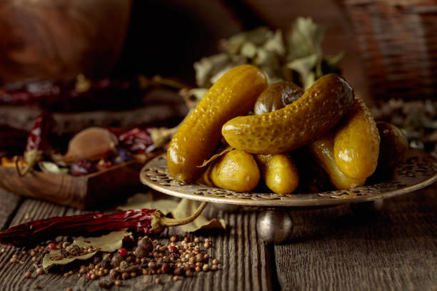 Pickled cucumbers with ingredients for making a delicious brine on an old wooden table.