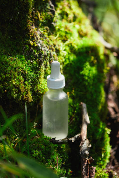 istock Clear dropper bottle resting on green moss in a forest environment 2193976499