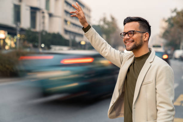 istock Confident Young Professional With Smartphone Hailing Cab During Evening Commute 2193977949