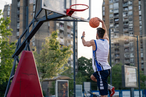istock Young Athletic Basketball Player Soaring High For Dramatic Urban Dunk 2193978116