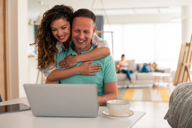 istock Smiling Partner Couple Enjoying Technology Time Together in Bright Kitchen Space 2193979126