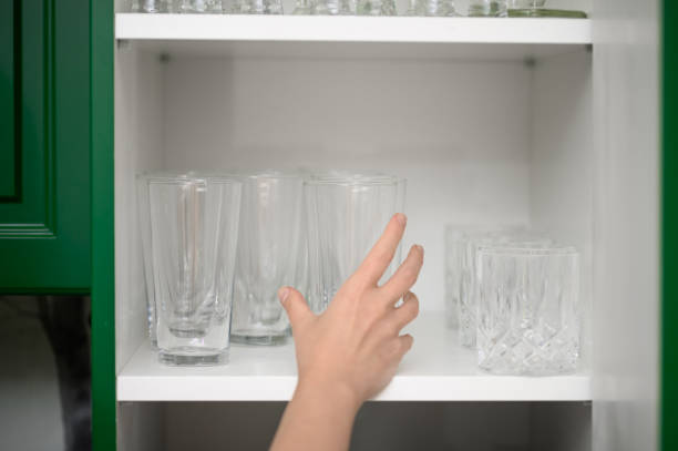 istock Home kitchen tidying up, clean polished glass for drinks in a white kitchen cabinet 2193982986