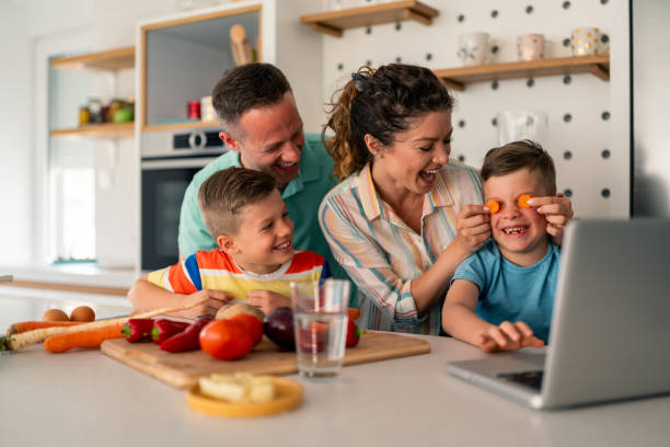 istock Joyful Family Sharing Kitchen Time While Learning New Cooking Skills Online 2193983108