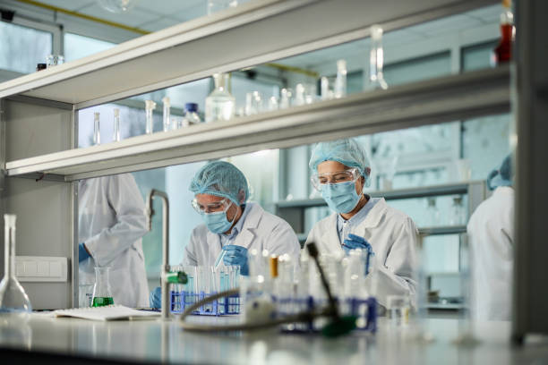Team of scientists working on a virus in laboratory. Group of experts analyzing poisonous chemicals while working in laboratory. antiviral drug stock pictures, royalty-free photos & images
