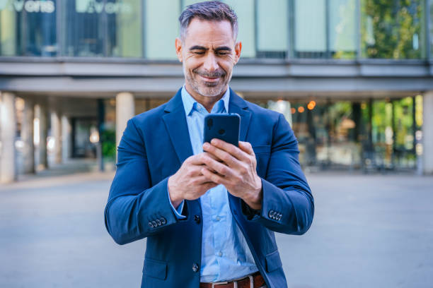 istock Confident businessman using smartphone outdoors, 2193987894