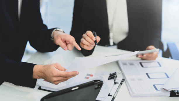 istock Close up of business professionals analyzing documents and data during a meeting 2193988996