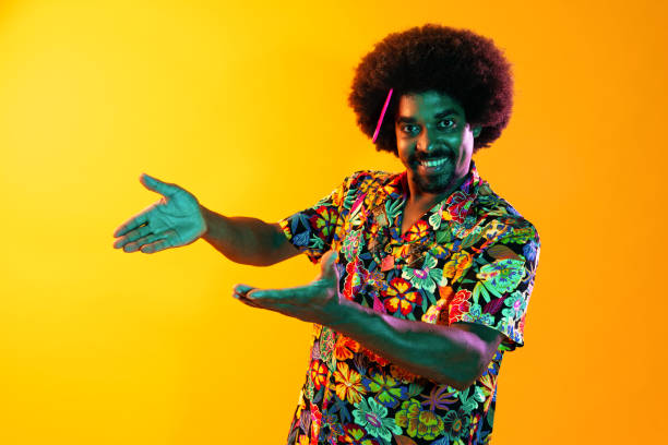 African man portrait in studio on colorful background - Cool black young male with stylish attire posing , creative colored lighting