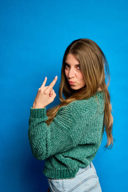 istock Young woman gesturing small amount with fingers on blue background 2193989443