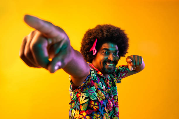 African man portrait in studio on colorful background - Cool black young male with stylish attire posing , creative colored lighting