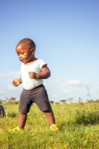 A beautiful African baby boy playing outdoors at a sunset all alone