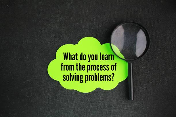 istock magnifying glass and colored paper with questions What do you learn from the process of solving problems? Q and A concept 2193990537