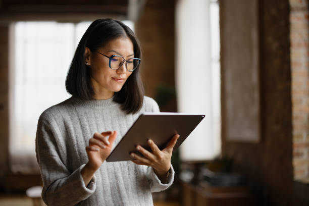 istock Smiling Asian female entrepreneur working on touchpad in the office. 2193991190