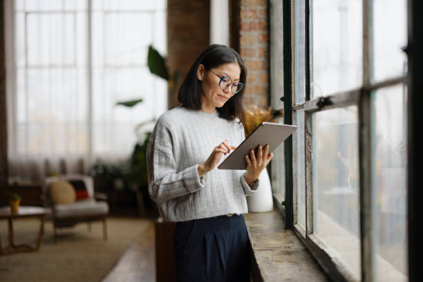 istock Asian female entrepreneur working on touchpad by the window. 2193991221