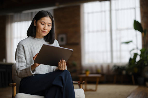 istock Chinese woman working on digital tablet at home. 2193991258