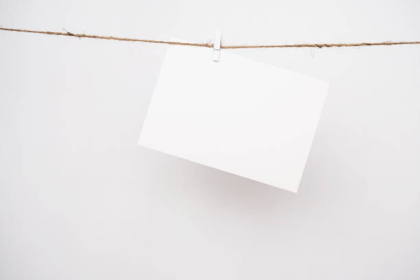 Mockup sheet paper. White card hanging on rope by pin.