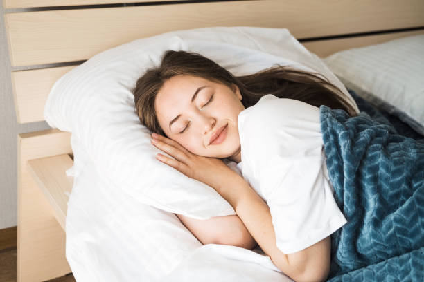 istock A beautiful young Caucasian brunette woman is sleeping on a bed. 2193992028